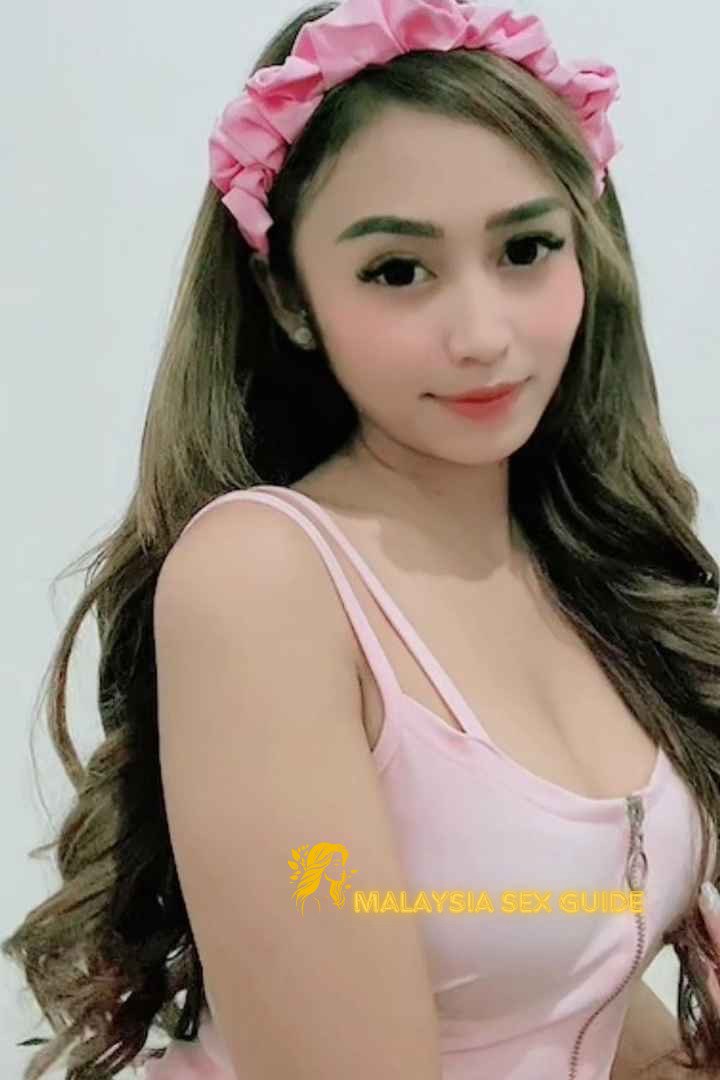 Attractive Malay woman wearing a pink headband and top.
