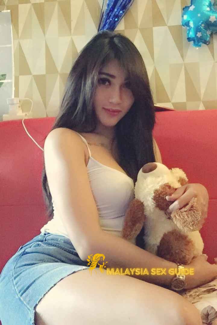 Attractive KL escort girl posing with a stuffed animal.
