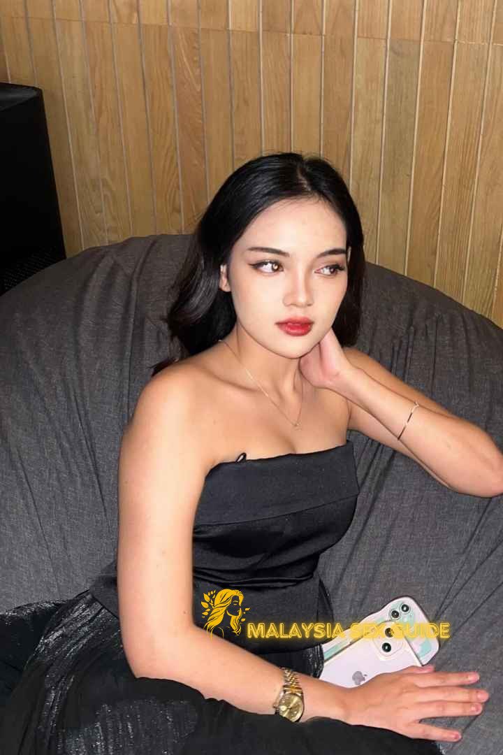 Attractive young woman in a black strapless dress, relaxing on a beanbag chair.