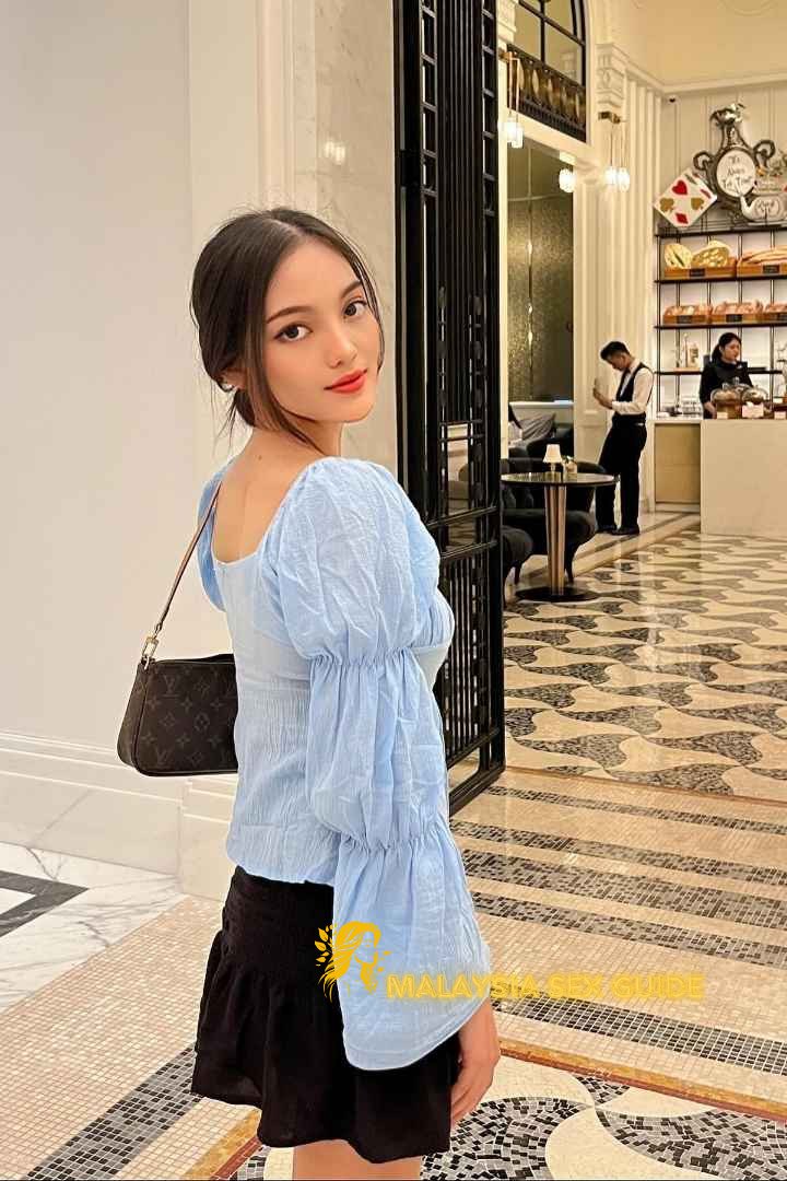 Young woman in a light blue blouse and black skirt in a luxurious hotel.