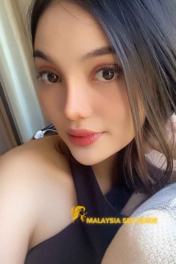 Attractive young woman in a black top. KL Escort Outcall services.