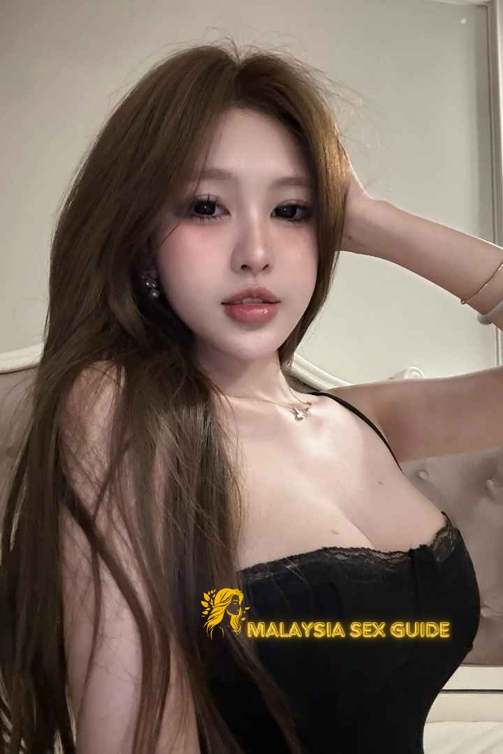 Attractive young woman with long brown hair, wearing a black top.