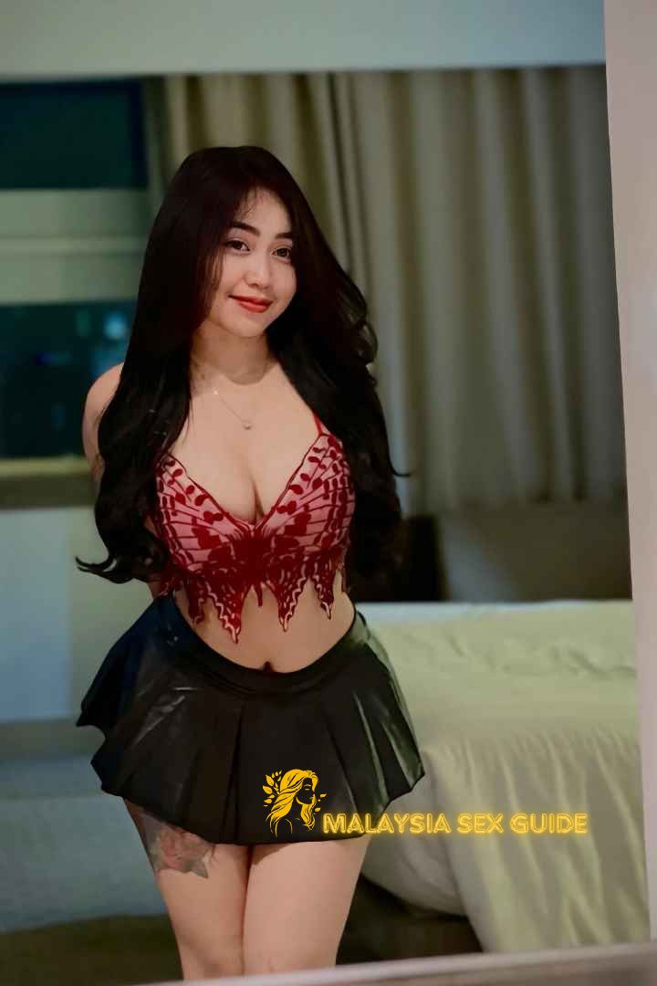 Attractive Malay woman in red top and black skirt
