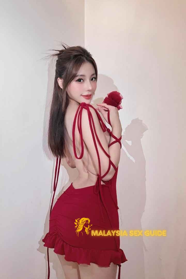 Woman in red backless dress. Malaysia sex guide.