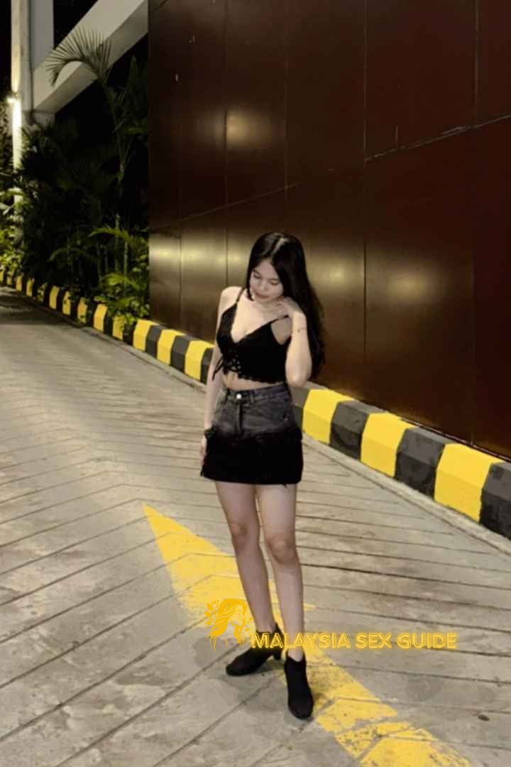 Young woman in black top and denim skirt in Kuala Lumpur.