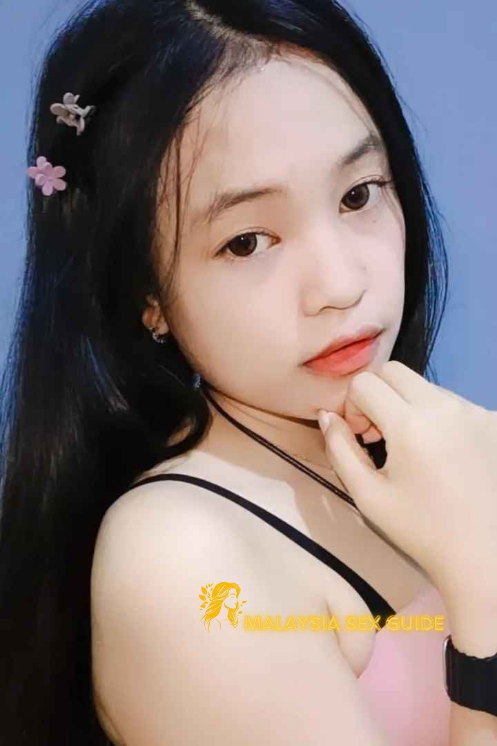 Attractive young woman with dark hair, wearing a pink top.
