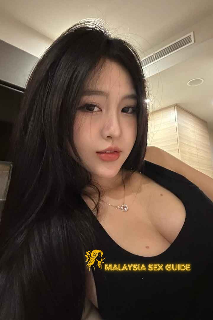 Attractive young woman with long dark hair, wearing a black top.