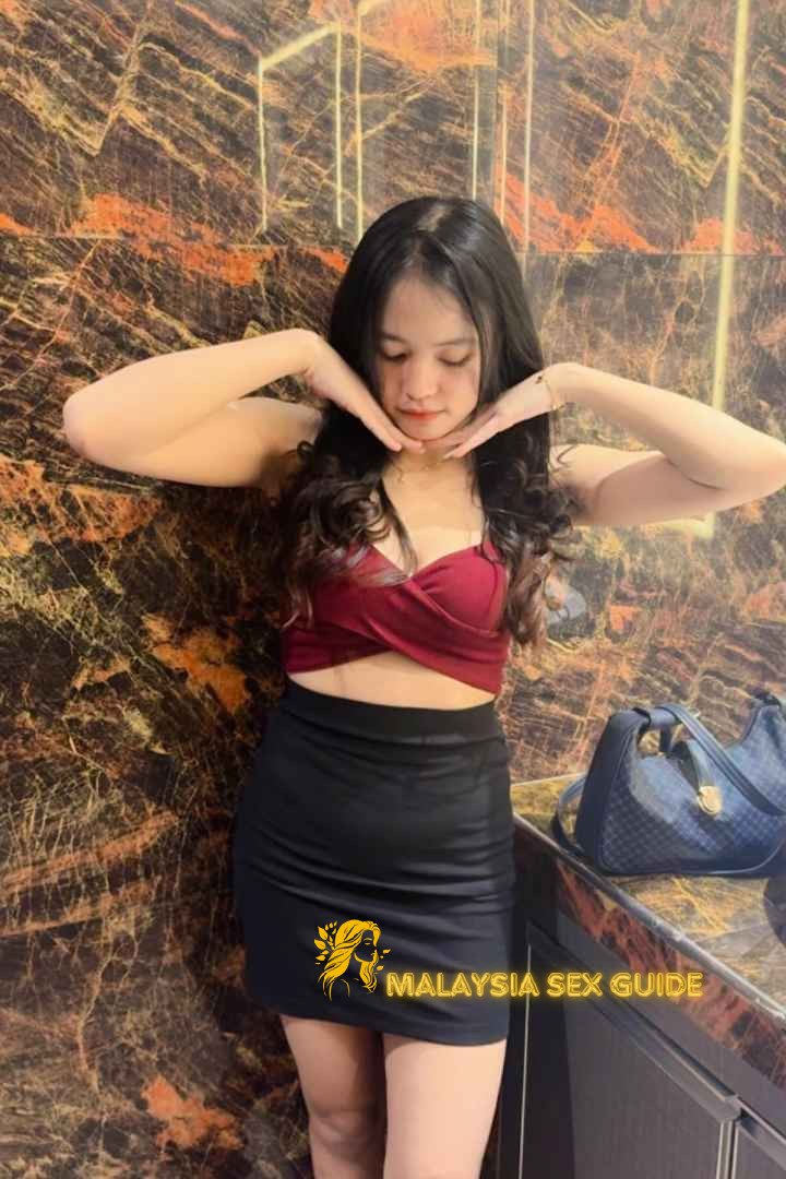 Attractive young woman in a red top and black skirt. Kuala Lumpur escort.