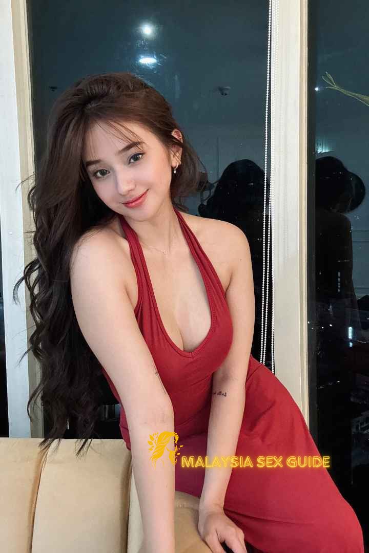 Attractive woman in a red halter dress. KL Escort Outcall.