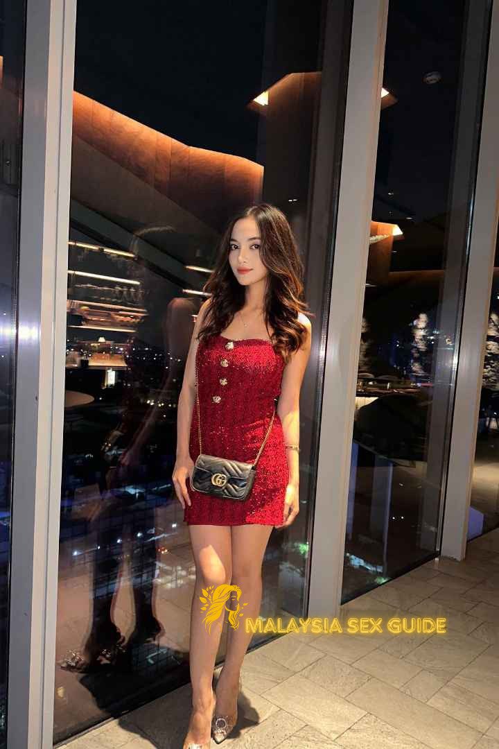 Attractive woman in red dress at KL nightspot.