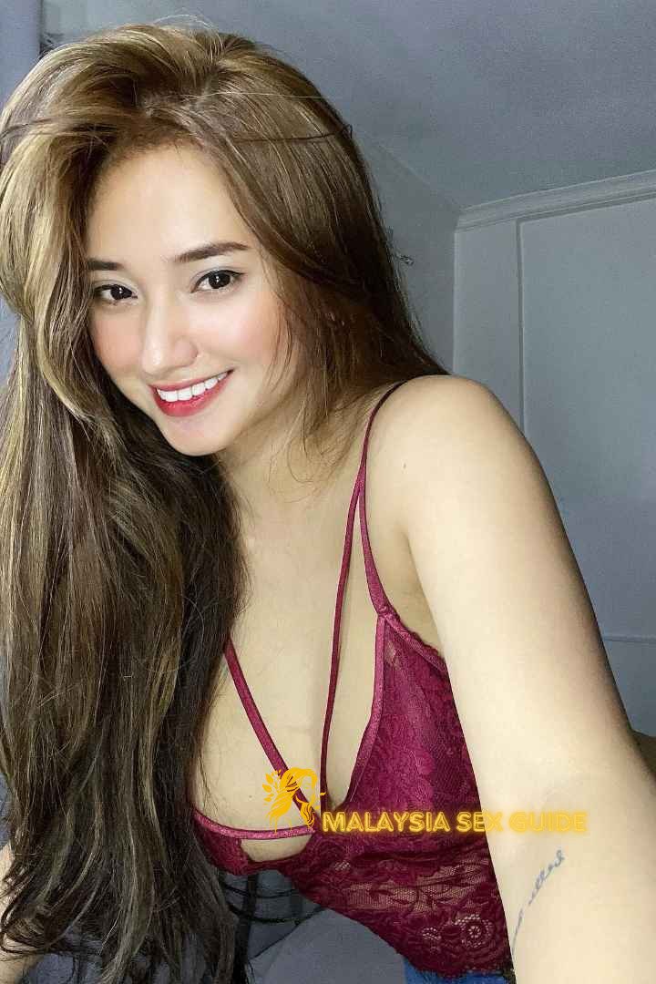 Attractive young woman in a burgundy lace top. KL escort outcall.