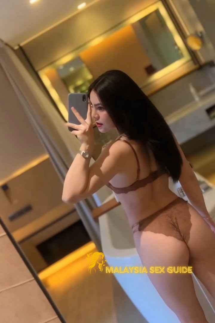 Woman in lingerie taking a selfie in a bathroom.