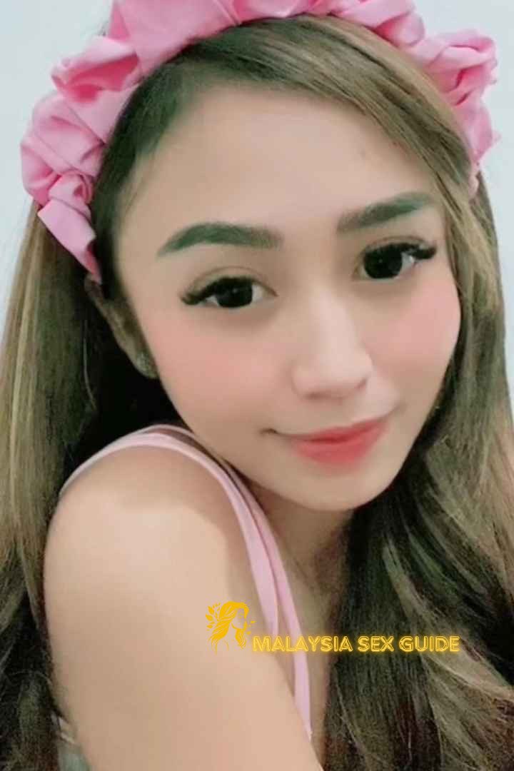 Attractive Malay woman wearing a pink headband.